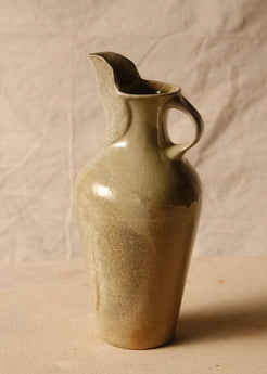 Woodfire Carafe on canvas, angled view showing the loop handle on the right and tall pulled spout facing left.
