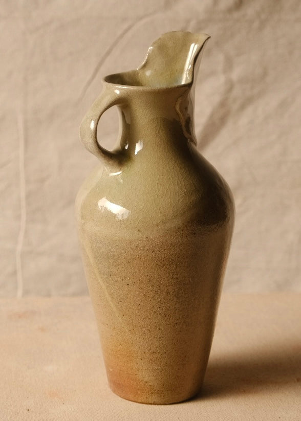 Woodfire Carafe viewed from the side, highlighting the arched handle on the left and tall spout on the right.