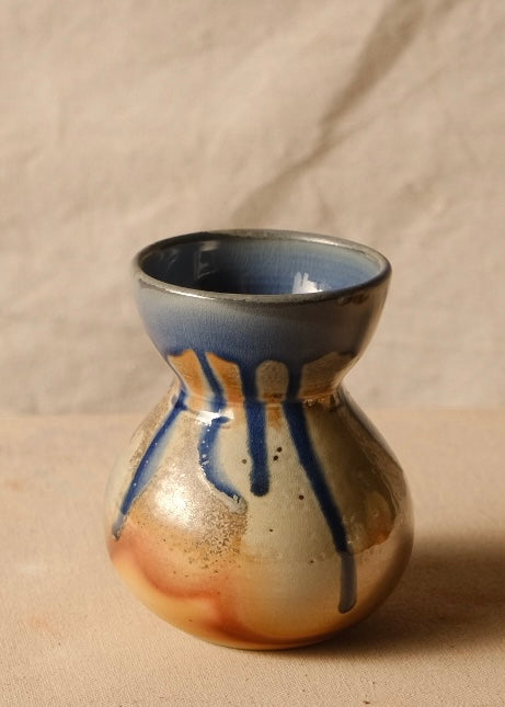 Woodfire Sake Carafe #1 turned slightly, highlighting dripping glaze lines down a bulbous ceramic belly.
