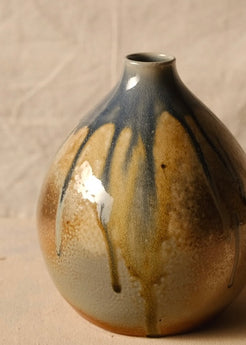 Woodfire Orbe Vase close-up on the reverse side, showing dark runs of glaze flowing toward the unglazed base.