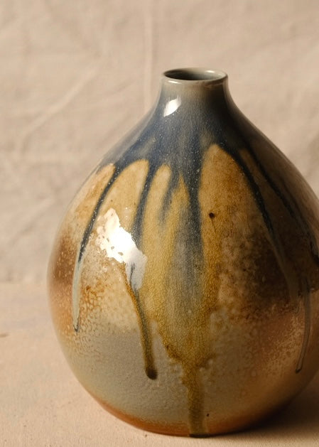 Woodfire Orbe Vase close-up on the reverse side, showing dark runs of glaze flowing toward the unglazed base.