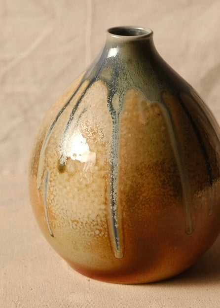 Woodfire Orbe Vase angled to show lighter ash-deposit patterning and long vertical glaze drips.
