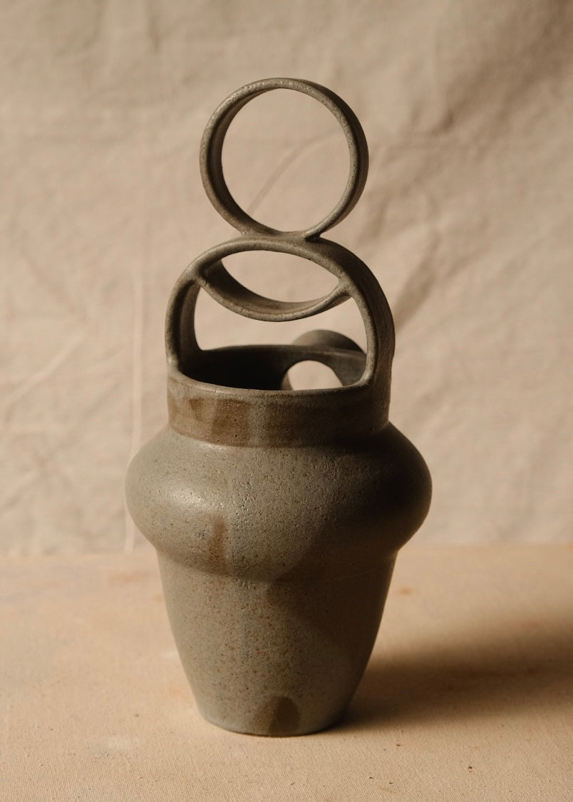 Rising Moon stoneware pitcher viewed from behind, highlighting the smooth back wall and stacked circular bridge handle.