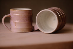 Lavender Salt Big Mug standing upright beside a second mug resting on its side to reveal a glazed interior.