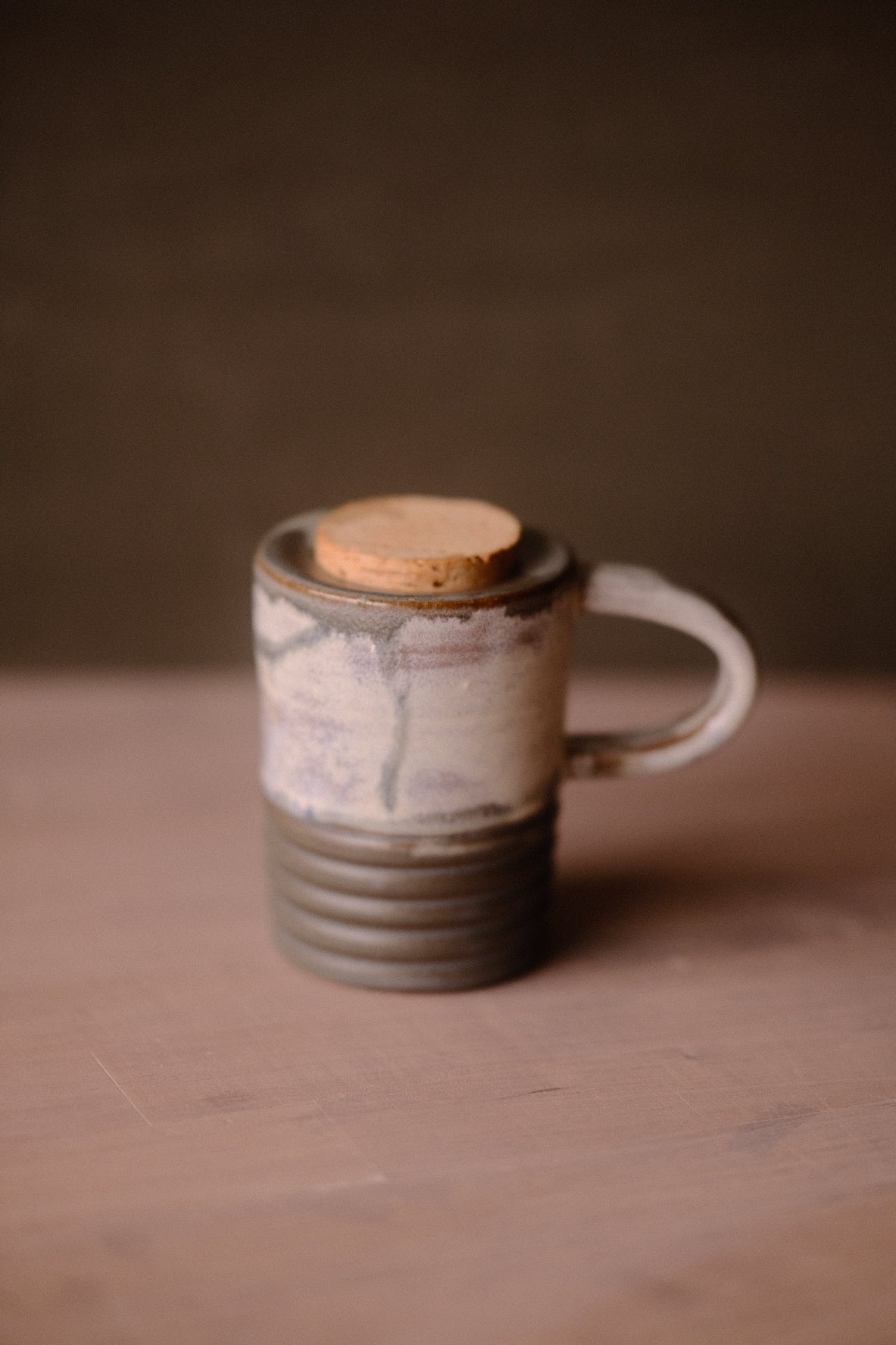 Stormy Sky Traveller travel mug with cork lid, handle on right. Shows pale grey textured top half and ridged grey bottom.