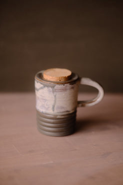 Stormy Sky Traveller travel mug with cork lid, handle on right. Shows pale grey textured top half and ridged grey bottom.