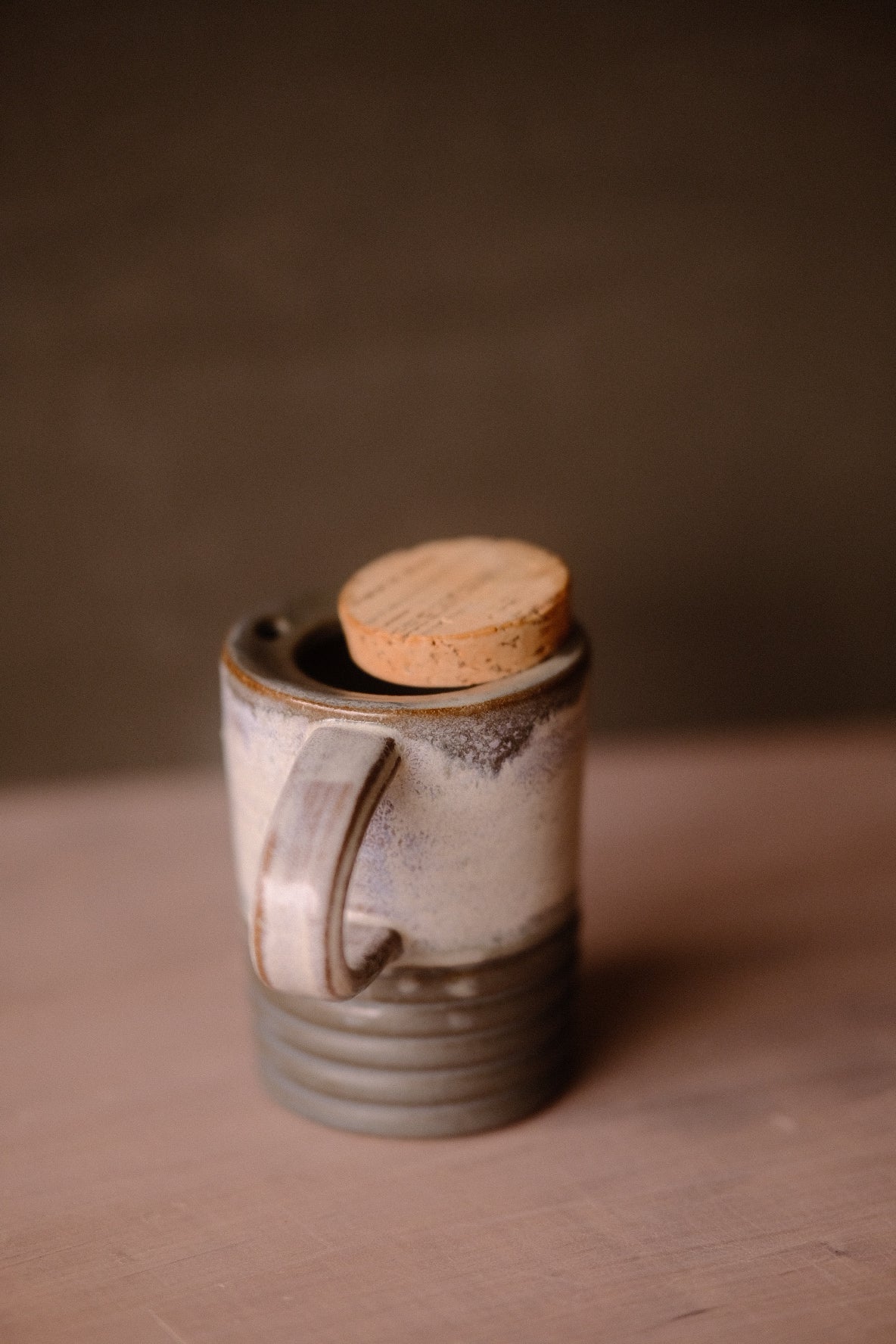 Stormy Sky Traveller mug with handle on left, cork stopper seated in the rim opening, mottled grey-and-cream body.