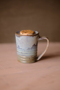 Secret Cenote Traveller Mug seen from the front with its handle turned right, highlighting mottled glaze over ribbed ridges.