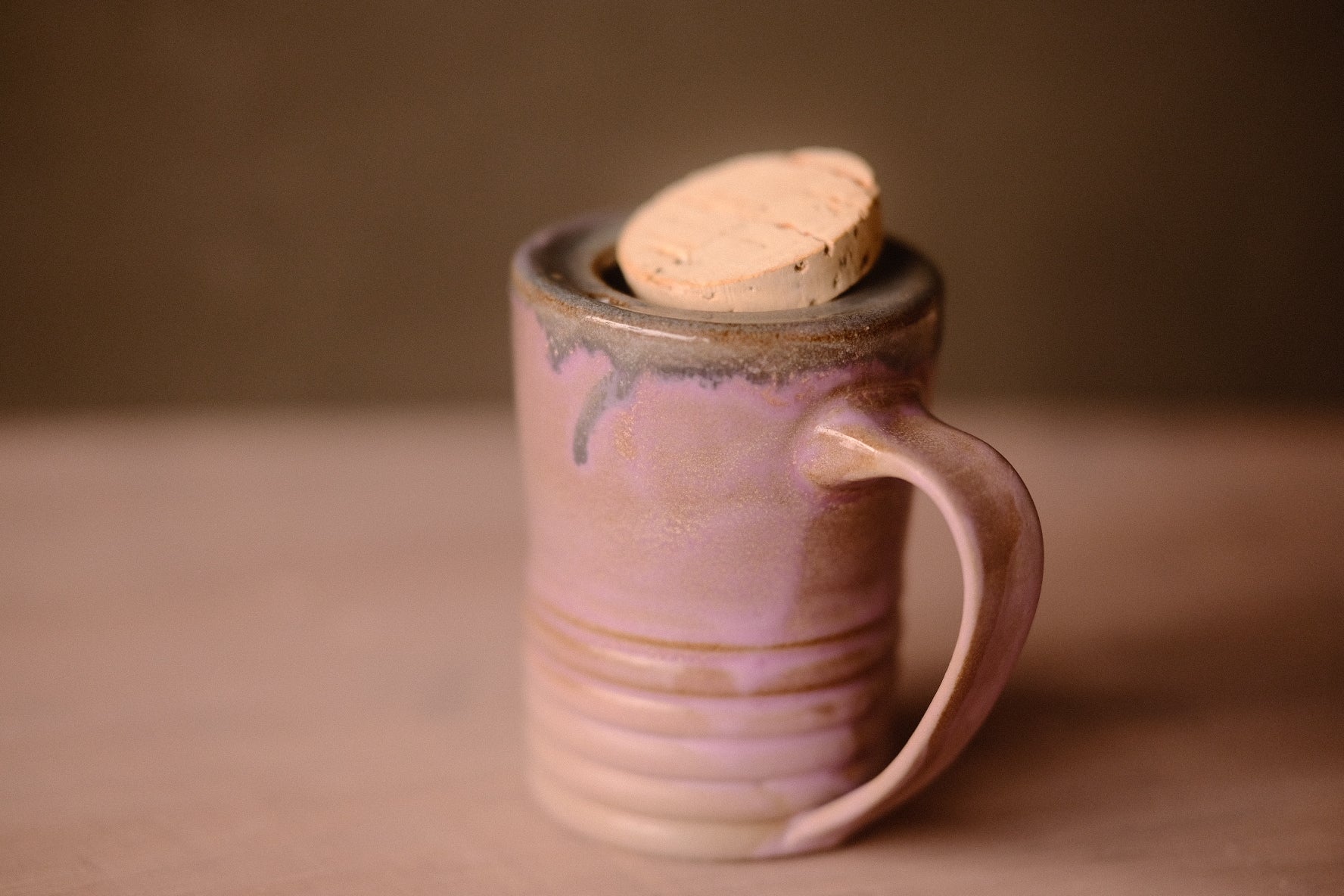 Lavendar Storm Traveller mug with a tilted, resting cork stopper showing the built-in top rim and curved handle.
