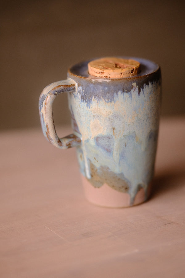 Secret Cenote Tall Traveller ceramic mug standing with handle to the left, dripped glaze, raw clay base, and cork lid.