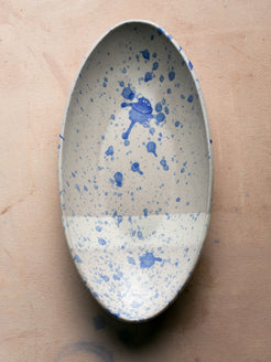 Wander Oval Server, top-down view of white dish with fine and bold blue splatter glaze.