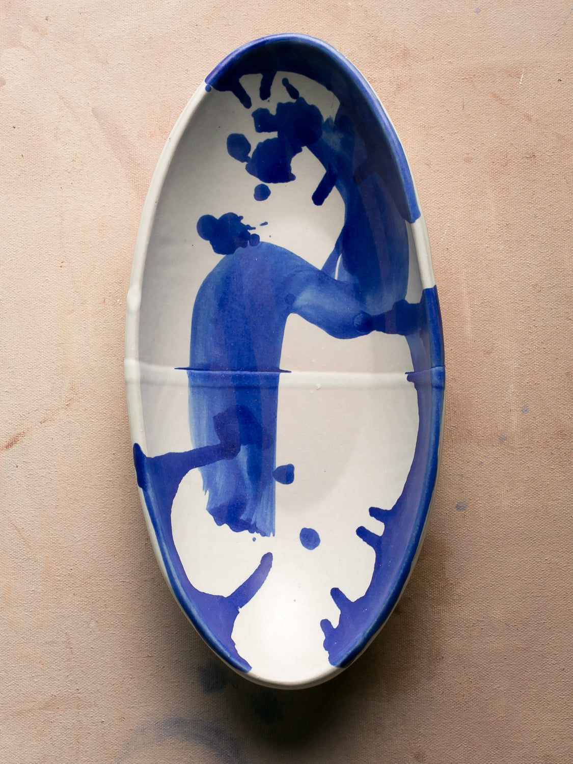 Wander Oval Server, overhead shot of white glazed dish featuring bold blue brushwork.