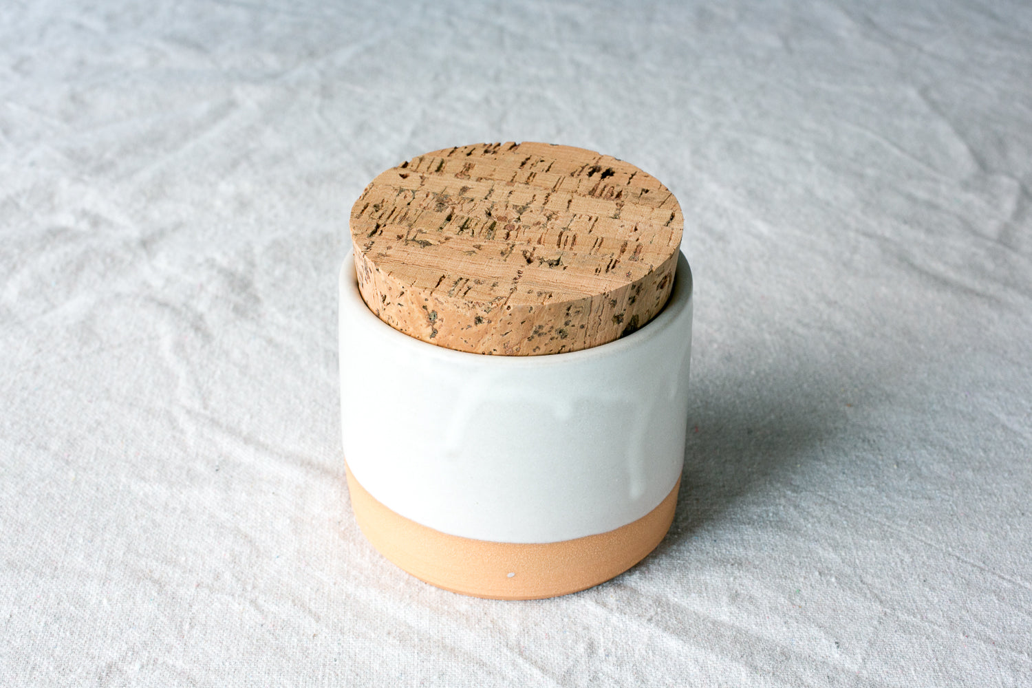 Wander Salt Jar with gloss white glaze dripping over a raw exposed clay base and cork lid.