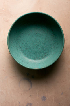 Wander Serving Bowl: direct overhead shot of a deep green speckled stoneware bowl with straight sides.