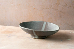 Wander Footed Oval Server in speckled grey glaze with a subtle stripe, resting on its raised pedestal foot.