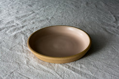 Fat Rim Dinner Plate with soft blush-pink interior glaze and unglazed stoneware rim on linen fabric.