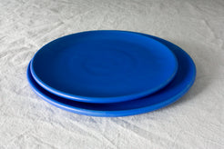 Horizon Dinner Plate: two stacked plates in vivid royal blue sitting on an off-white linen surface.