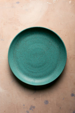 Wander Serving Platter featuring a speckled turquoise glaze, seen from directly above on a tabletop.
