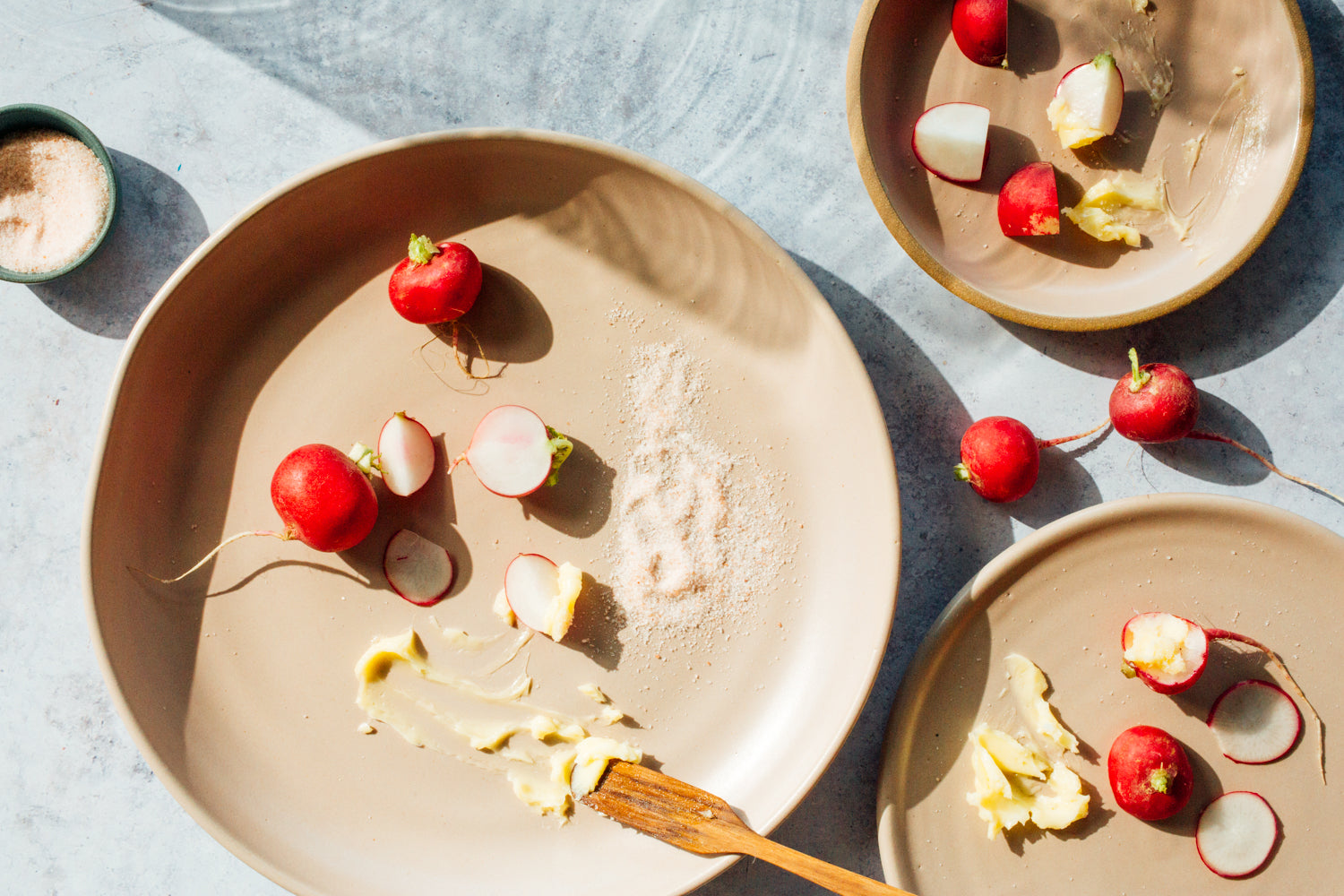 Horizon Dinner Plate: high angle with butter, radishes, and flaked salt alongside two smaller plates.
